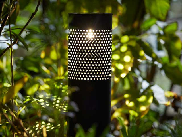 Solar powered black circular light in bush