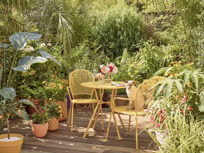 Mature garden with deck and yellow bistro set