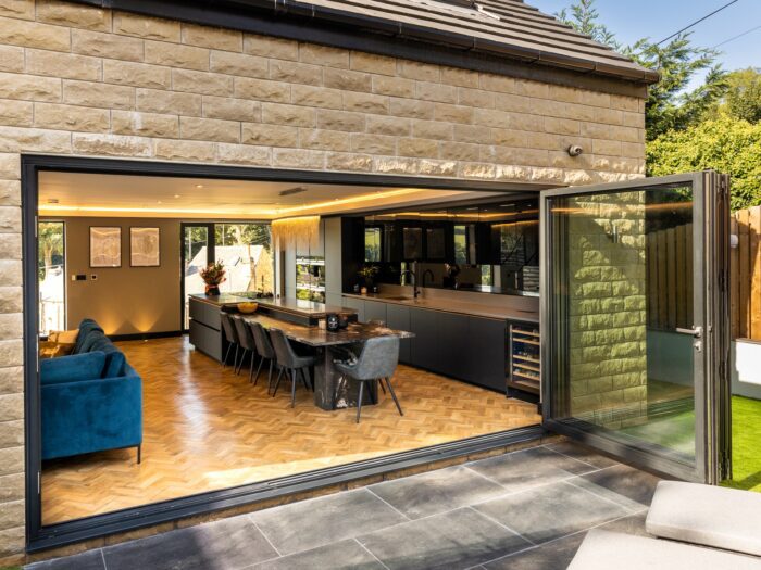 Large format bifold doors folded back to reveal kitchen living room