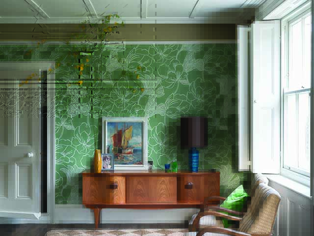 Green wallpaper feature wall in lounge with framed print and oak furniture, goodhomesmagazine.com