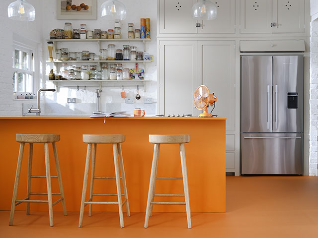 A pop of orange gives a simple seasonal refresh in this kitchen. Image Credit: Carpetright