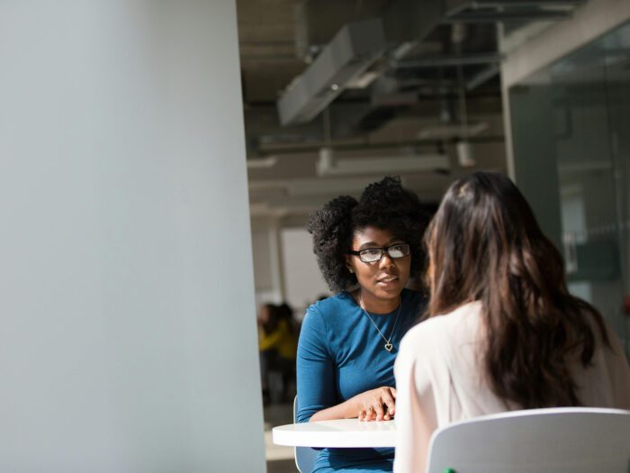 A photo of two women talking at a table