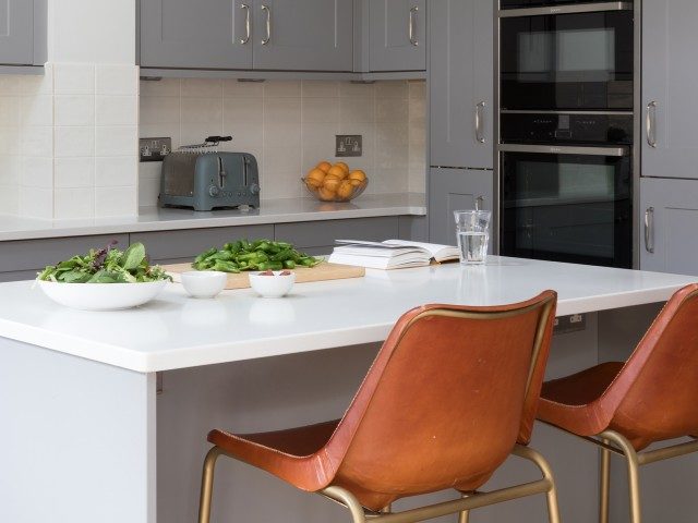 white kitchen island with leather bar stool chairs in grey kitchen