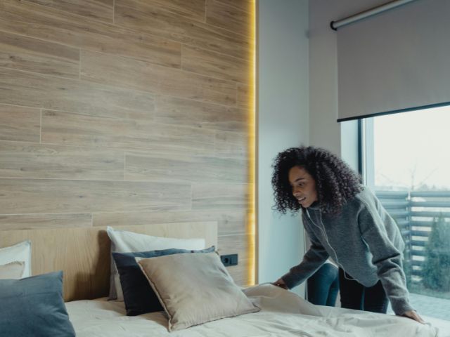 Woman making her bed in a modern bedroom