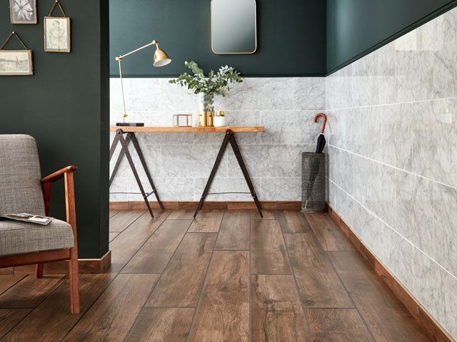 large marble effect tiles on wall in a hallway with dark green walls and dark wood flooring by Walls and Floors